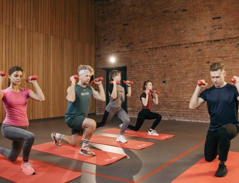 Indoor group workout session with dumbbells focusing on strength and fitness.
